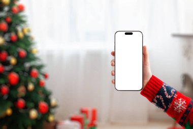 Samimi bir Noel ortamında boş bir telefon ekran modeli, tatil tasarımları, mobil uygulamalar, mevsimlik promosyonlar ve neşeli pazarlama görselleri için ideal