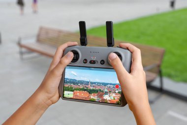 Drone denetleyici canlı bir şehir görüntüsünü ekranda gösteriyor, kentsel izleme, çekim, haritalama veya akıllı şehir uygulamaları için kullanılır
