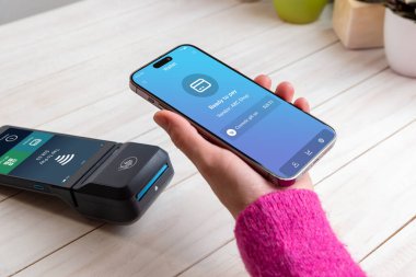 Mobil cüzdan uygulaması, müşteri POS terminalinin yanında hatasız bir işleme hazır bir akıllı telefon tutarken, ödemeye hazır hale gelir.