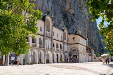 Ostrog Manastırı, Karadağ 16 Ağustos 2020 Aşağı Manastır Kompleksi, dik kayalıkların altındaki avluda yürüyen ziyaretçiler