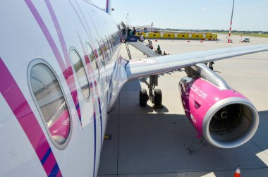 Budapeşte, Macaristan 14 Temmuz 2017 Yolcular Wizz Hava Yolları 'na Budapeşte Ferenc Liszt Uluslararası Havaalanı' ndaki havaalanı apronunda mobil merdivenlerle biniyor.