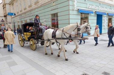 Viyana, Avusturya 7 Ekim 2017 Geleneksel at arabası turistlerle birlikte tarihi şehir merkezinde yaya caddesinde ilerliyor.