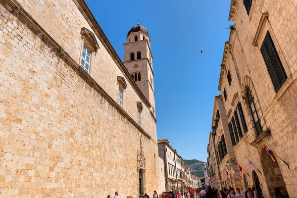 Dubrovnik, Hırvatistan, 1 Mayıs 2022 Stradun Caddesi boyunca Dubrovnik Katedrali 'nin çan kulesi ve tarihi Eski Şehir' deki turist kalabalığıyla birlikte