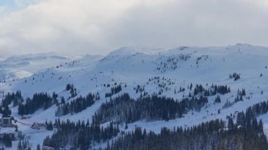 Jahorina 'daki karlı dağ sırtlarından oluşan hava manzarası engin dağlık araziyi, kış atmosferini ve el değmemiş doğal manzarayı yakalıyor.