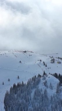 Gondol ve yamaçlı alp kayak zirvesinin mobil seyahat içeriği ve kış mevsiminin tanıtımı için optimize edilmiş dikey hava videosu