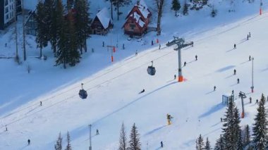 Bosna-Hersek 'in Jahorina kenti 14 Ocak 2026: Poljice kayak pistinin bir kış günü kayakçıların üzerinde hareket eden gondol kulübeleriyle hava ayrıntıları