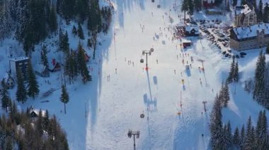 Jahorina, Bosna-Hersek 14 Ocak 2026: Gondol kulübeleri ve kayakçılarla birlikte Poljice kayak yamacının havadan görünüşü.