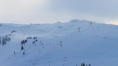 Jahorina, Bosna-Hersek 14 Ocak 2026: Yamaçlarda kayakçılar ve kış boyunca faaliyet gösteren gondol kulübeleriyle Jahorina dağlarının havadan görünüşü