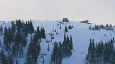 Jahorina, Bosna-Hersek 14 Ocak 2026: Kamera yükselirken Poljice gondolunun hava görüntüsü kayak yamaçlarını ve çevresindeki araziyi ortaya çıkarıyor