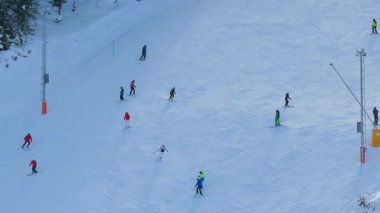 Bosna-Hersek 'in Jahorina kenti 14 Ocak 2026: Kayakçıların hava manzarası, Jahorina kayak merkezindeki günlük kış tatilini gösteren karla kaplı bir yamaçta yayıldı