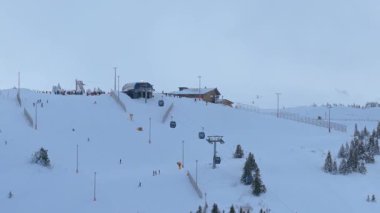 Jahorina, Bosna-Hersek: 14 Ocak 2026: Çevredeki dağ arazisi boyunca uzanan kayak yamaçlarına sahip Poljice gondolunun üst istasyonu havadan görünüşü