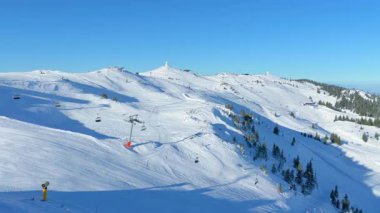 Boş yamaçları ve teleferiği olan kayak merkezinin geniş hava manzarası kış sporları sezonunun açılışından önce dağ manzarasını gösteriyor.