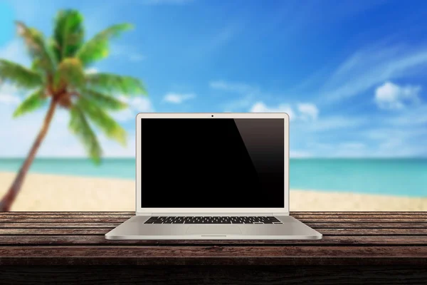 Білий ноутбук на столі з пляжною пальмою і морем на фоні макет презентації — стокове фото