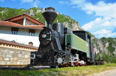 Demiryolu raylarında sergilenen tarihi buhar lokomotifi, geleneksel dar ölçü trenlerini, sanayi mirasını ve manzaralı dağ çevresindeki klasik ulaşım tarihini temsil ediyor..