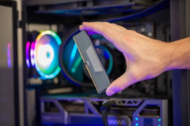 DDR5 RAM modülü RGB ışıklandırmalı oyun bilgisayarının önünde, yüksek performans sistemi için bellek güncellemesi