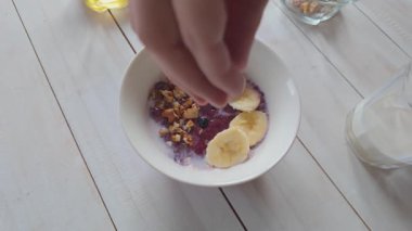 Yavaş çekim yulaf ezmesi kasesine taze yaban mersini koyuyoruz. Sağlıklı kahvaltı için besleyici meyve sosu.