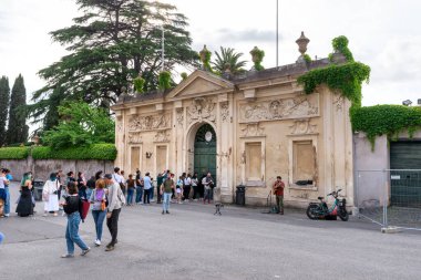 Roma, İtalya 23 Nisan 2025 Ziyaretçiler yeşillik ve klasik mimari ayrıntılarla çevrili tarihi giriş kapılarının yakınında toplandılar.
