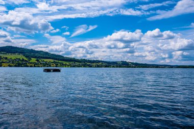 Gökyüzü bulutlu güzel bir göl manzarası - Meisterschwanden, İsviçre