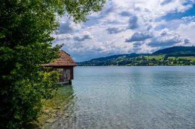 Gökyüzü bulutlu güzel bir göl manzarası - Meisterschwanden, İsviçre
