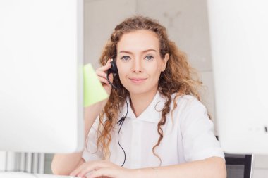 Operatör konuşuyor ve çağrı merkezinde kuyrukta bekleyen müşteri için sorunu düzeltmeye çalışıyor.