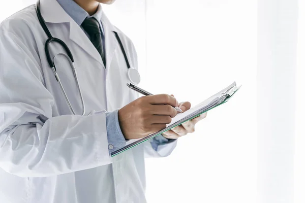 Doctor write something to the list on his note , healthcare and medical concept.