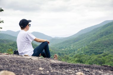 Gezgin bir uçurumun kenarında oturuyor ve dağa bakıyor..