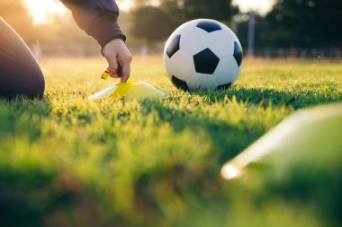 Antrenör futbol antrenman malzemelerini hazırlar..