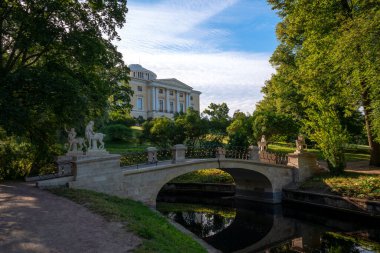 Pavlovsky Parkı 'ndaki Centaur Köprüsü güneşli bir yaz gününde Pavlovsky Sarayı' nın arka planına karşı Rusya 'nın St. Petersburg kentinde bahçe ve park rezervi