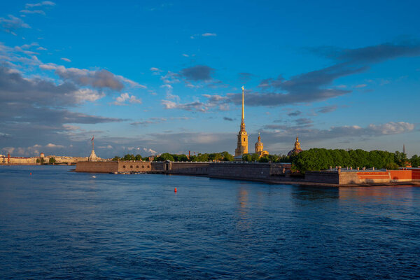 View of the Peter and Paul Fortress and Vasilievsky Island from the Trinity Bridge over the Neva River on a sunny summer morning with clouds, St. Petersburg, Russia
