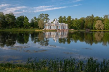 Güneşli bir yaz akşamında Tsarskoye Selo 'daki Catherine Park' ta büyük bir göletin kıyısında Pavilion Grotto. Puşkin, St. Petersburg. Rusya.