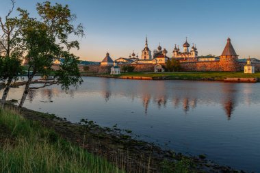 Beyaz Deniz Koyu kıyısındaki Solovetsky Manastırı bulutsuz bir yaz akşamında batan güneşin ışınlarında Solovetsky Adası, Arkhangelsk Bölgesi, Rusya