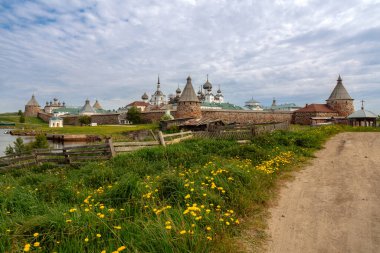 Solovetsky köyündeki toprak yol manzarası, arka planda Solovetsky Manastırı bulutlu bir yaz günü, Solovetsky Adası, Arkhangelsk Bölgesi, Rusya