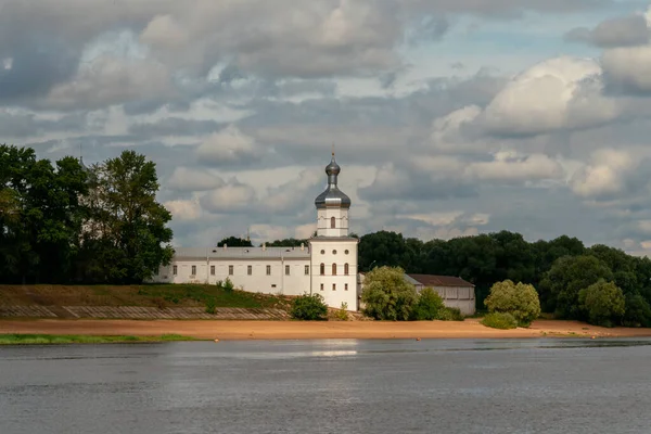 俄罗斯Veliky Novgorod 夏日阳光明媚的St George Yuriev 修道院的墙壁和Volkhov河上有积雨云的Naquilovsky塔 — 图库照片