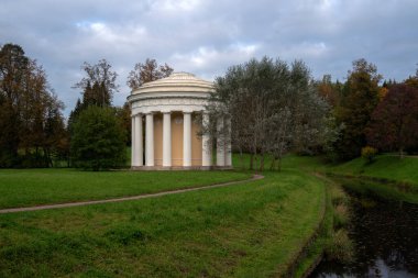 Pavlovsky Sarayı 'ndaki Slavyanka Nehri kıyısındaki Dostluk Tapınağı ve Rusya' da sonbahar bulutlu bir sabahta Park Kompleksi manzarası