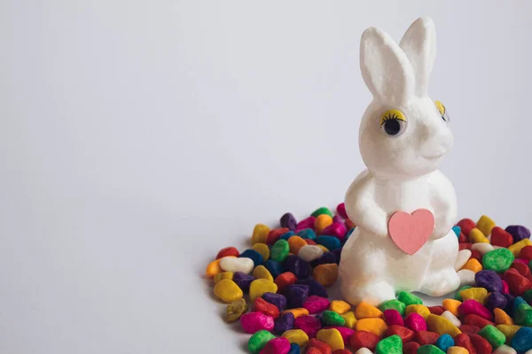 Beyaz Paskalya tavşanı mı yoksa elinde pembe bir kalp olan tavşan mı? Yaratıcı kopyalama alanı.