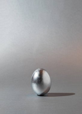 Gri arka planda gümüş ve parlak Paskalya yumurtası. Tek renkli 2021 Paskalya kompozisyonu. Modern asgari çağdaş biçim.