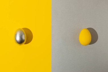 Sarı ve gümüş arka planda iki renkli yumurta. Metni boş olan modern Paskalya kartı. Asgari Mutlu Paskalya konsepti 2021.