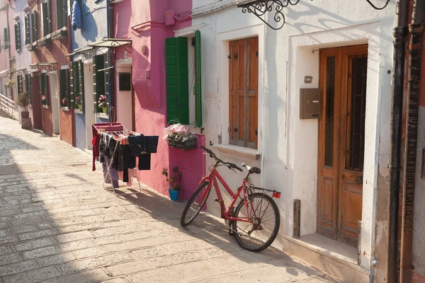 Altes rotes Fahrrad geparkt lange eine Außenmauer in burano island, v — Stockfoto