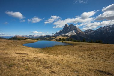 Sass de Putia Dolomites 'te küçük bir alp gölünün arkasında.