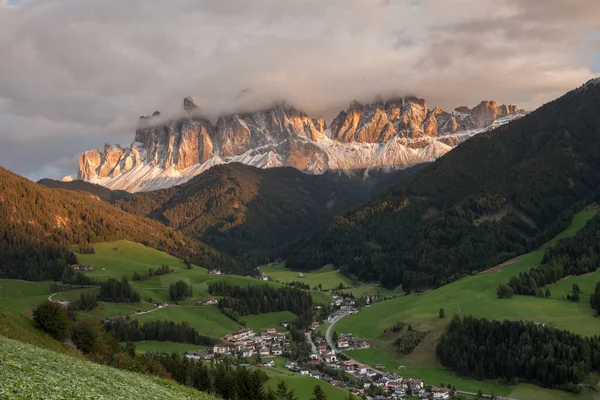 Small Italian mountain town of St. Magdalena in Val di Funes at sunset
