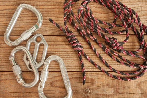 Equipamento de montanha para escalar em fundo de madeira — Fotografia de Stock