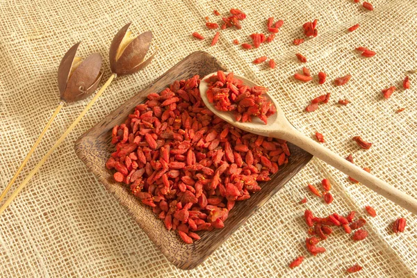 Goji frijoles en una taza de madera, escena country — Foto de Stock