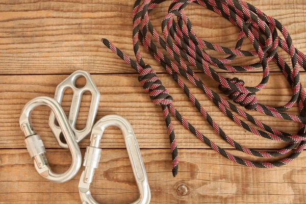 Equipamento de montanha para escalar em fundo de madeira — Fotografia de Stock