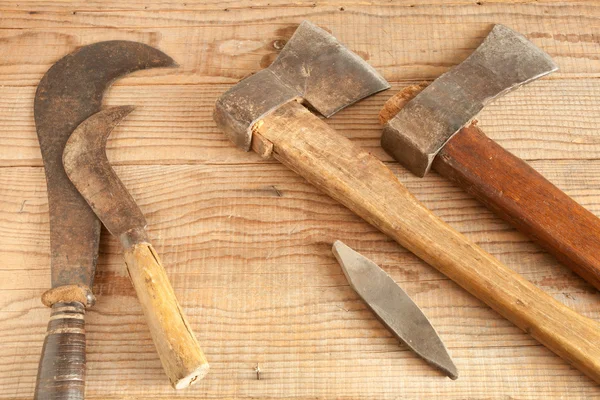 Два устаревших и бывших в употреблении ножа и крючка на деревянном фоне — стоковое фото