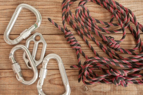 Equipamento de montanha para escalar em fundo de madeira — Fotografia de Stock