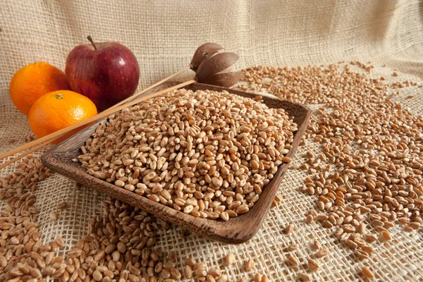 カントリー スタイルの木製カップに自然食品として小麦 — ストック写真