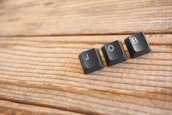 "JOB" wrote with keyboard keys on wooden background — Stock Photo, Image