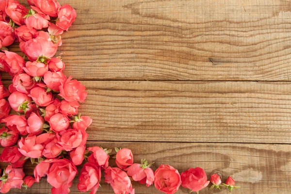 Červené růže na dřevěném pozadí — Stock fotografie