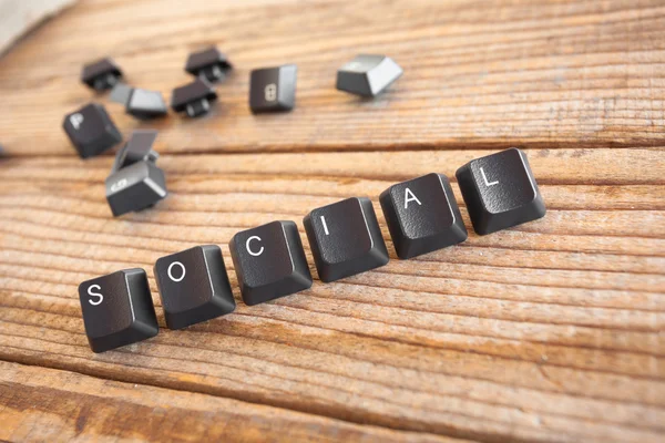 "social "wrote with keyboard keys on wooden background — стоковое фото