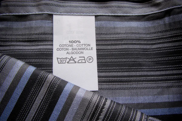 Washing instructions label on cotton vertical stripes shirt — Stock Photo, Image